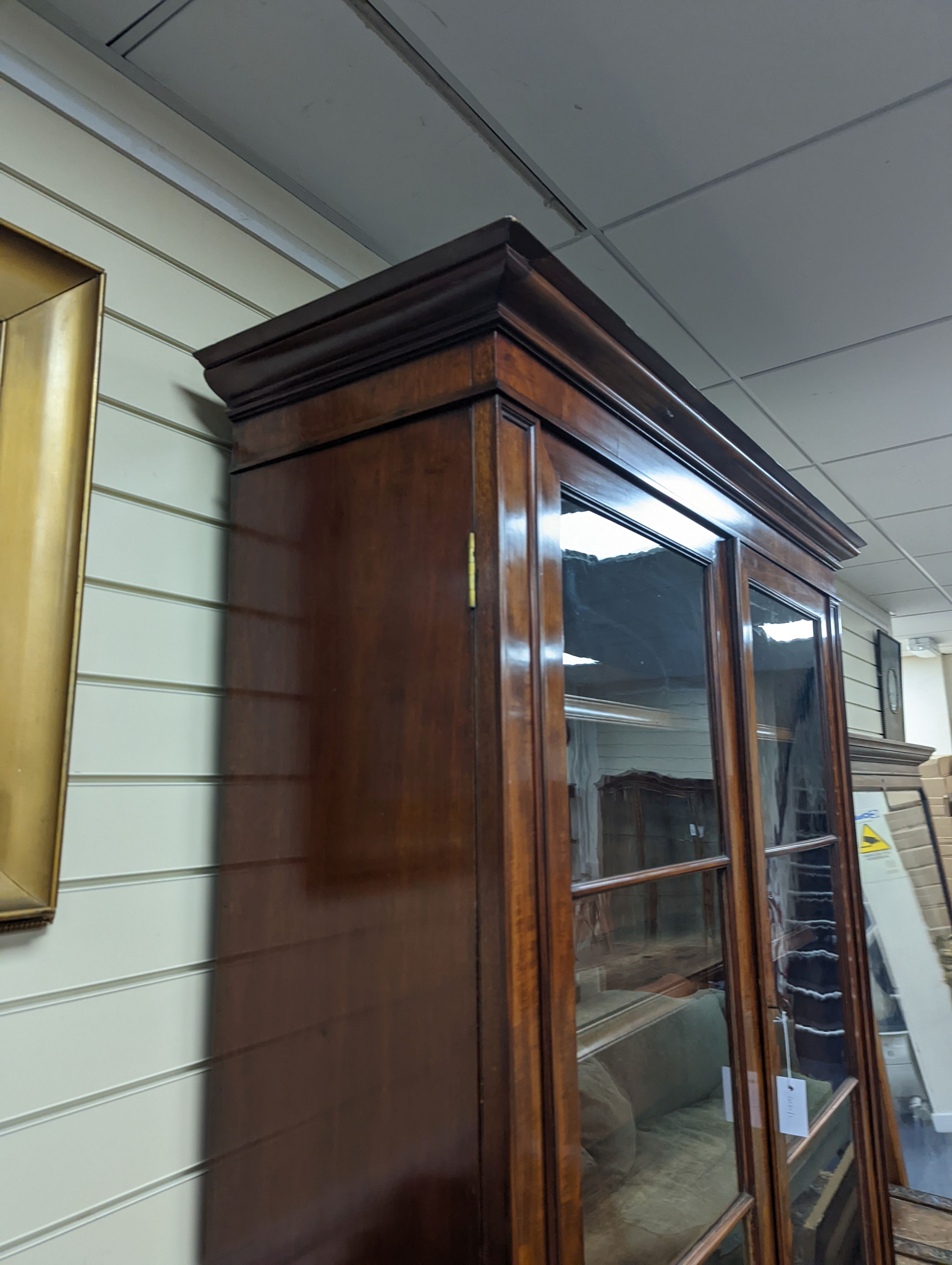 A Victorian mahogany bookcase fitted two drawers with panelled cupboard base, length 127cm, depth 49cm, height 228cm